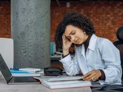 woman hunched over ledger at her desk after news of quickbooks desktop subscription cut off