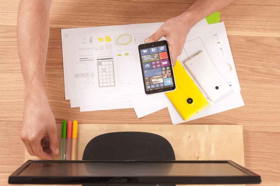 A man reviewing M365 Business plans and pricing options on his phone and computer screen.