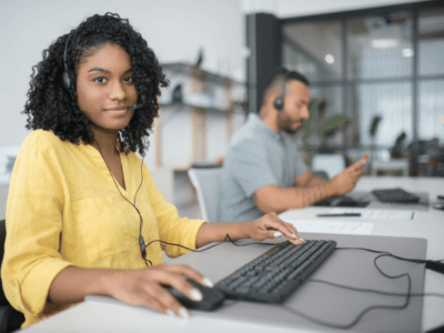 woman in yellow shirt providing IT support as part of a M365 managed services provider