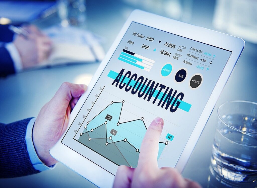 A person holding a tablet computer looking at screen with the words "Accounting" over a financial report, to compare Sage Intacct versus Sage 300