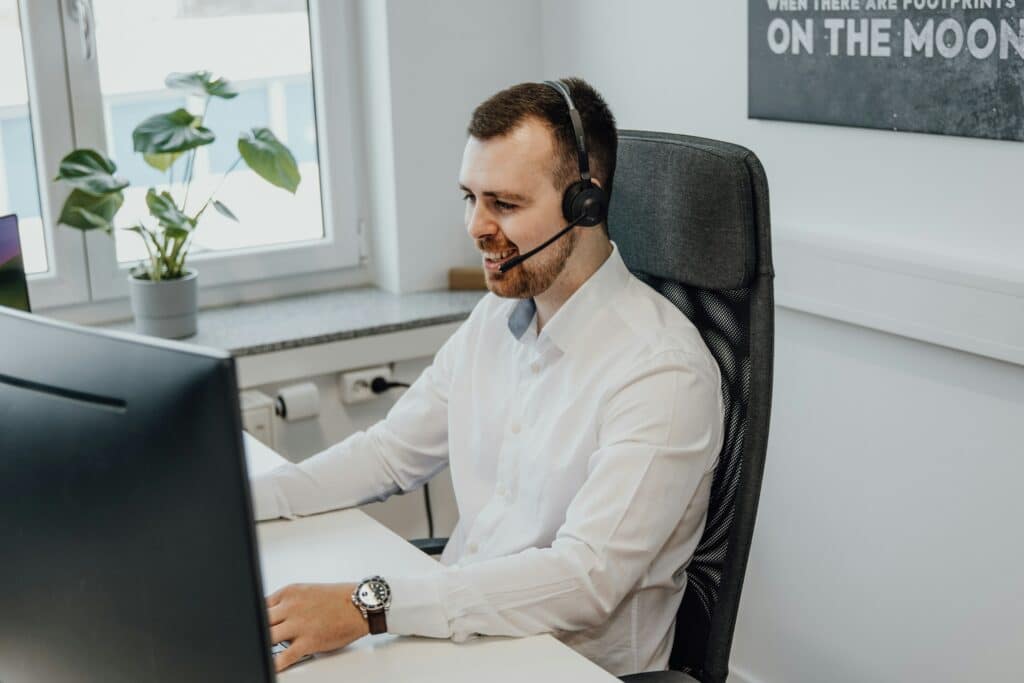 A man with a headset sitting at a desk in front of a computer screen providing managed IT support and service sin New Jersey (NJ)