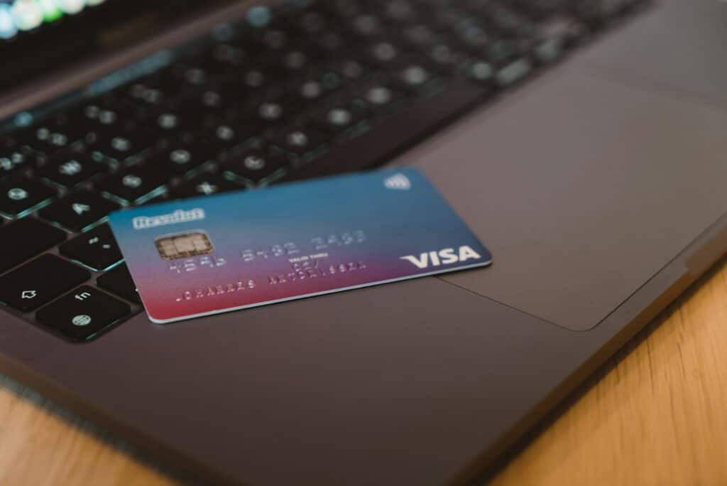 A blue and purple gradient Visa credit card resting on a laptop keyboard, representing the digital management of corporate credit cards discussed in this guide to Sage Intacct's credit card functionality.