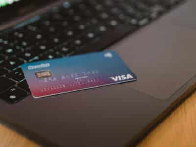 A blue and purple gradient Visa credit card resting on a laptop keyboard, representing the digital management of corporate credit cards discussed in this guide to Sage Intacct's credit card functionality.