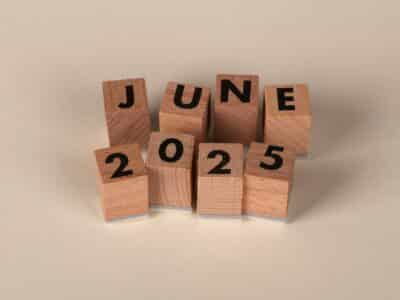 Wooden letter blocks arranged to spell "JUNE 2025" on a light background, representing the June 2025 cybersecurity news recap timeframe.
