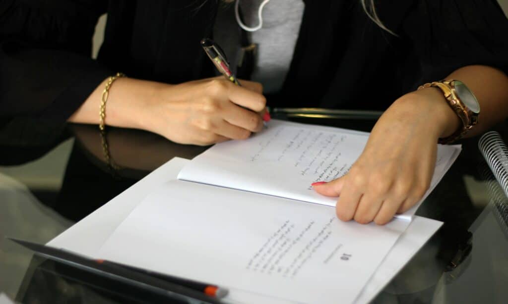 Business professional reviewing and annotating cybersecurity compliance documents with handwritten notes for threat assessment evaluation.