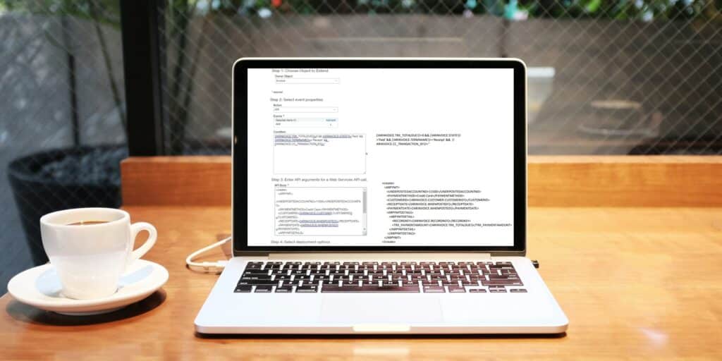 Laptop displaying Sage Intacct configuration screen with API settings and Smart Rules conditions on a wooden desk with coffee cup
