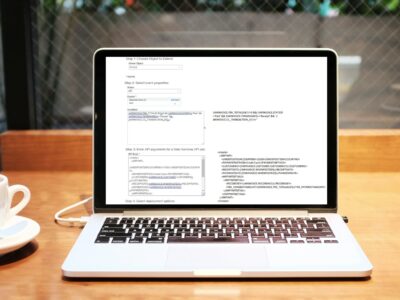 Laptop displaying Sage Intacct configuration screen with API settings and Smart Rules conditions on a wooden desk with coffee cup