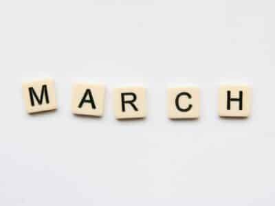 Five cream-colored letter tiles spelling "MARCH" arranged in a horizontal row against a white background.