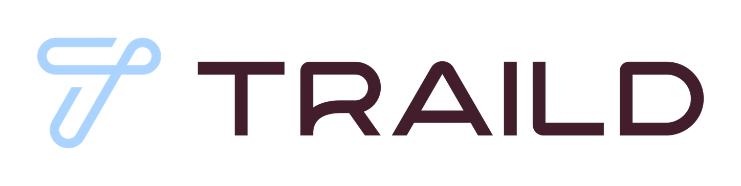 Traild logo with a light blue stylized "T" icon resembling intertwined loops to the left of the brand name "TRAILD" in dark maroon block letters against a white background.