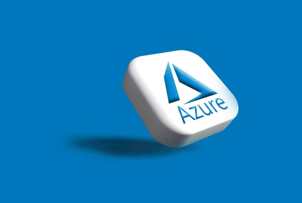 A 3D rendering of a white rounded square tile tilted at an angle, displaying the Microsoft Azure logo — a stylized blue letter "A" formed from three angled shapes above the word "Azure" in blue text — casting a soft shadow on a solid blue background.
